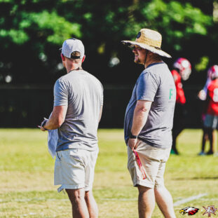 Photo of a coach Coach Duke talking to Athletic Director, Josh Vandergrift, clickable link to Edgewater High School's Athletic Trainers page to view list of athletic trainers.